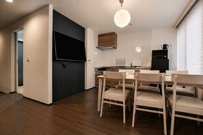 A modern kitchen with a dining area, wooden flooring, and a flat-screen TV. - Randor Residence Tokyo Suites (Tokyo)