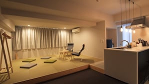 A modern living room with a sofa, chairs, a small table, and a kitchen area with a sink and countertop. - Randor Residence Tokyo Suites (Tokyo)