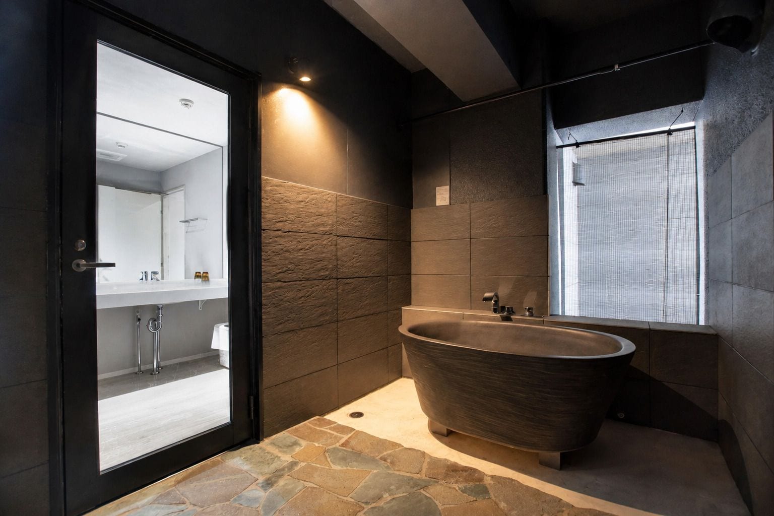 Une salle de bain moderne avec une baignoire sur pieds, un grand miroir et une fenêtre donnant sur un beau paysage.