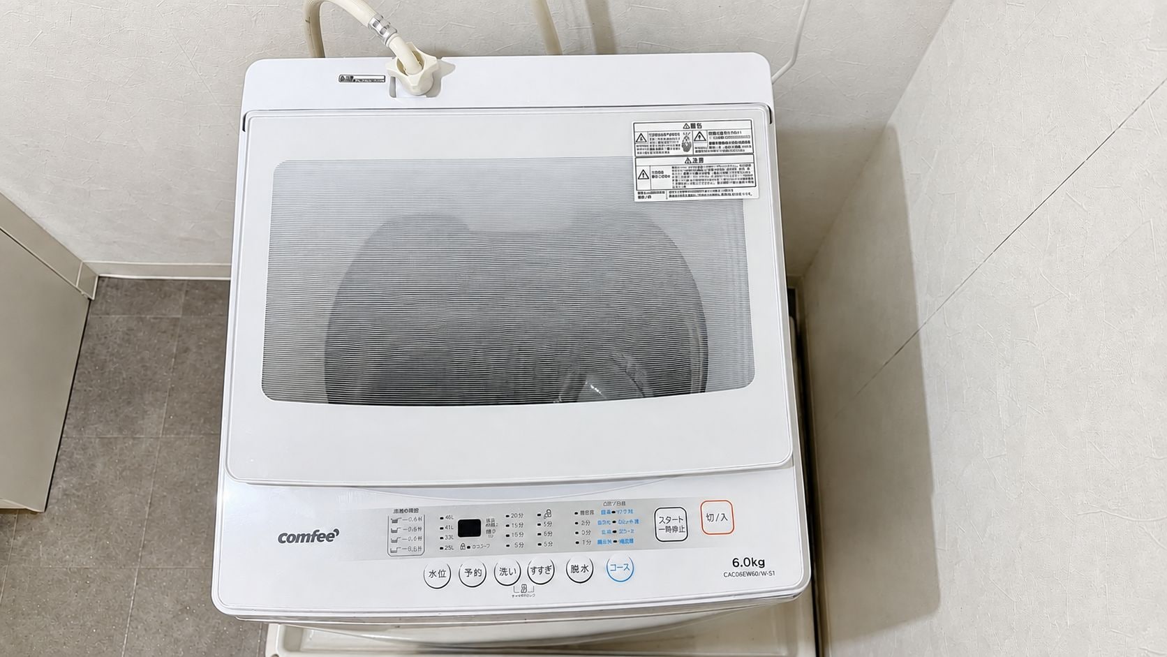 A white portable heater with a digital display and control buttons, placed on a tiled floor.