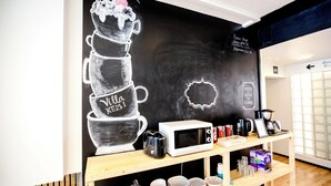 A kitchen area with a chalkboard wall, a microwave, a coffee maker, and various kitchen utensils. - Hostel Villa Kemi (Kemi)