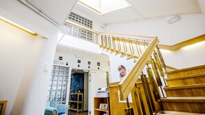 A staircase with wooden railings and a skylight above. - Hostel Villa Kemi (Kemi)