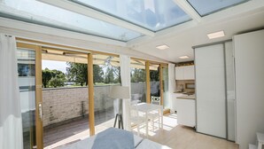 A modern bedroom with a skylight, a bed, a desk, and a view of the outdoors. - Hostel Villa Kemi (Kemi)