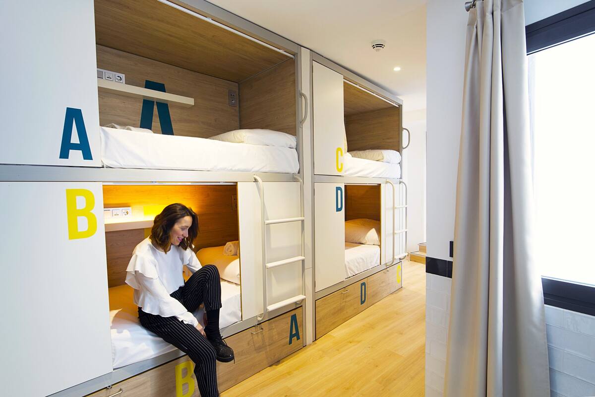 Ein Mehrbettzimmer mit Betten, die mit A, B, C und D beschriftet sind, und einer Leiter zwischen den Betten A und B.