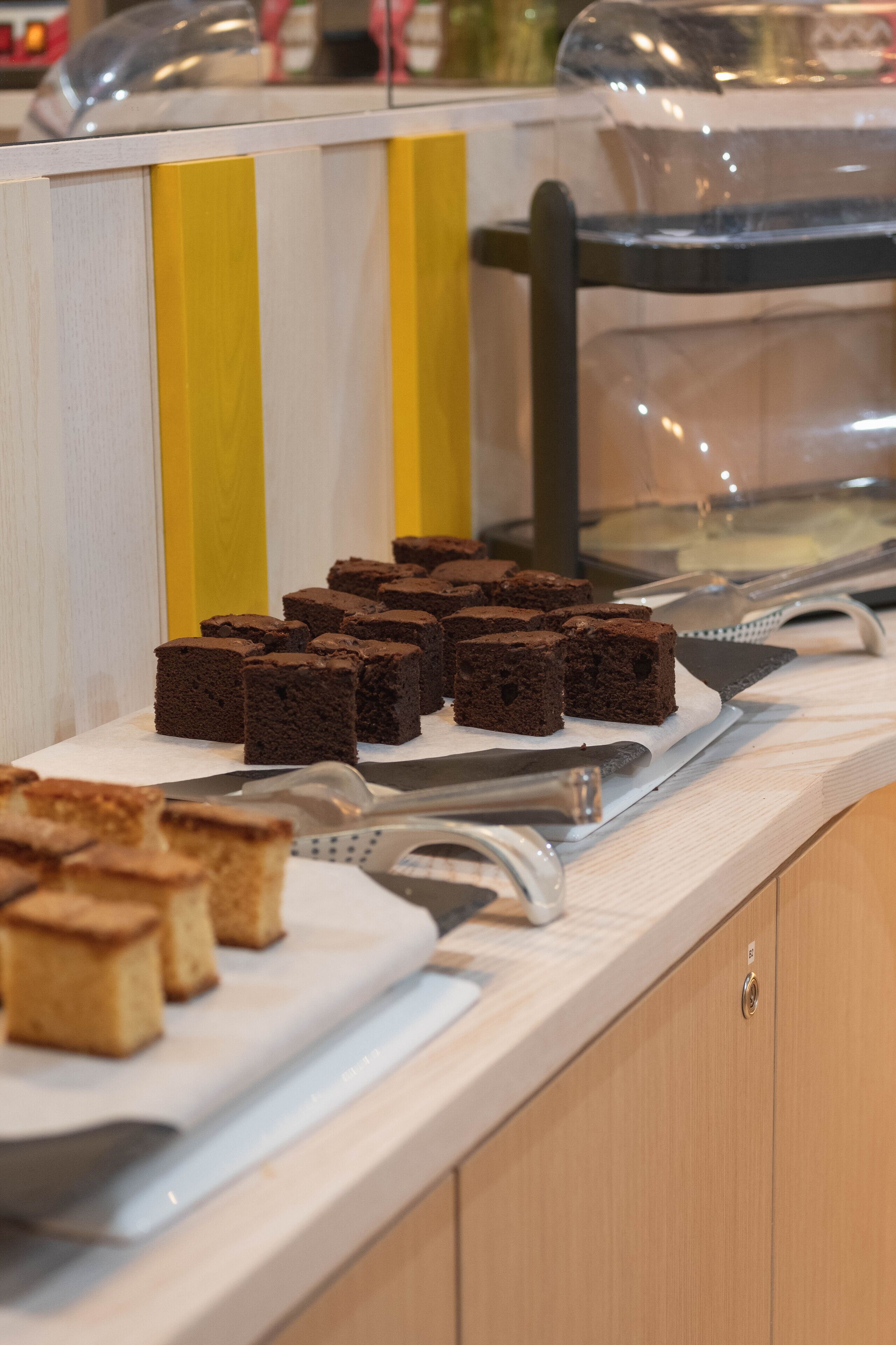 Una barra con bandejas de brownies y un cuchillo.