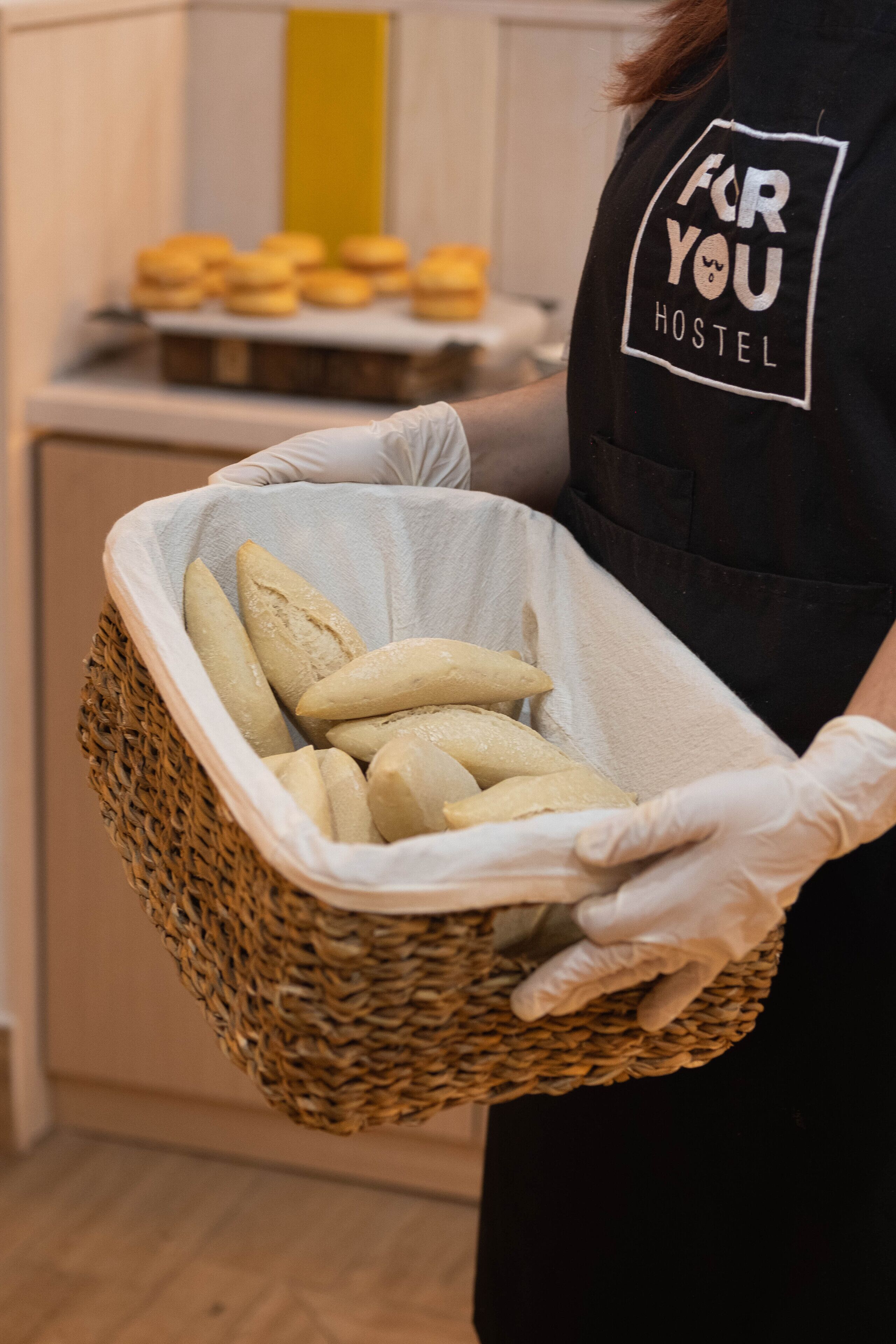 Eine Person hält einen Korb mit Baguettes.