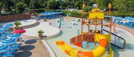 Un parc aquatique doté d’un grand toboggan, de plusieurs piscines et de chaises longues.