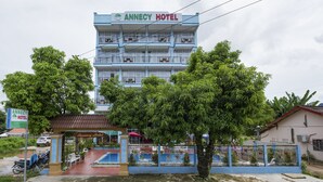 A multi-story hotel with balconies, a swimming pool, and a covered area. - Annecy Hotel Vang Vieng (Vang Vieng)