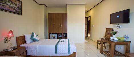 A hotel room with two beds, a desk with a chair, a television, and a painting on the wall.
