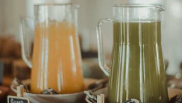 Dos jarras de bebidas con las etiquetas 'Suno Laranja' y 'Suno Detox' sobre una mesa de madera.