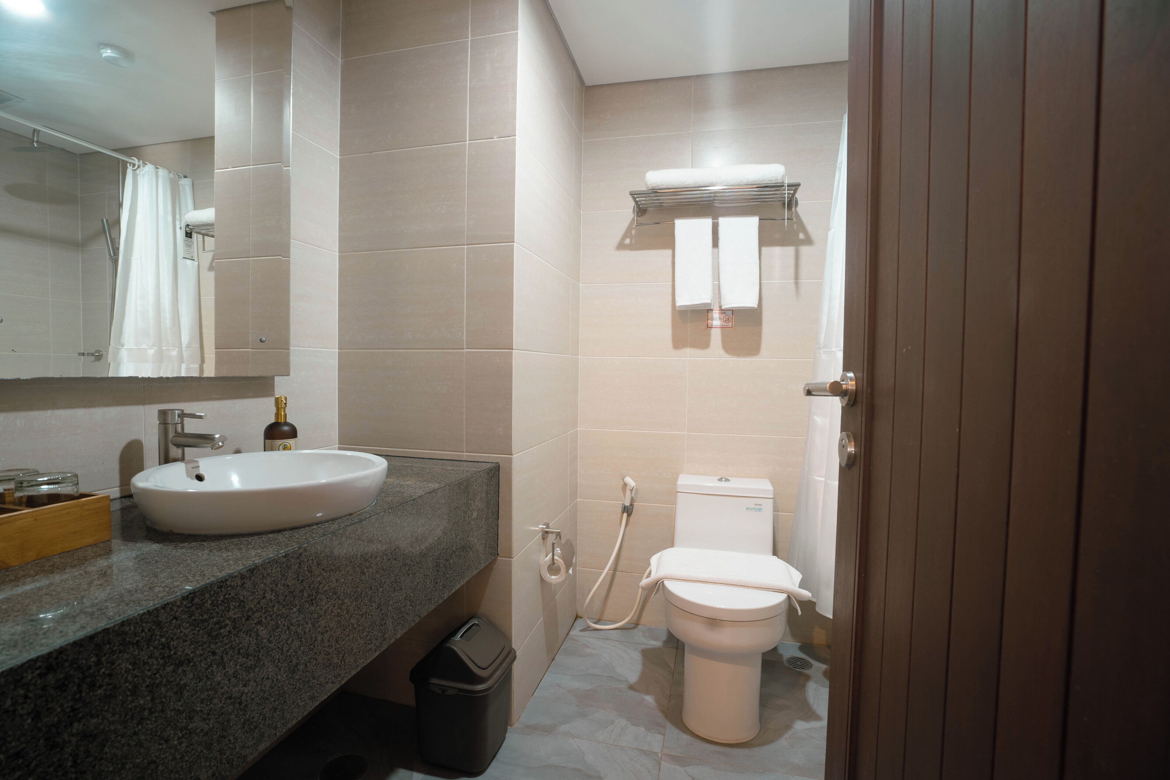 A bathroom with a sink, toilet, and shower curtain.