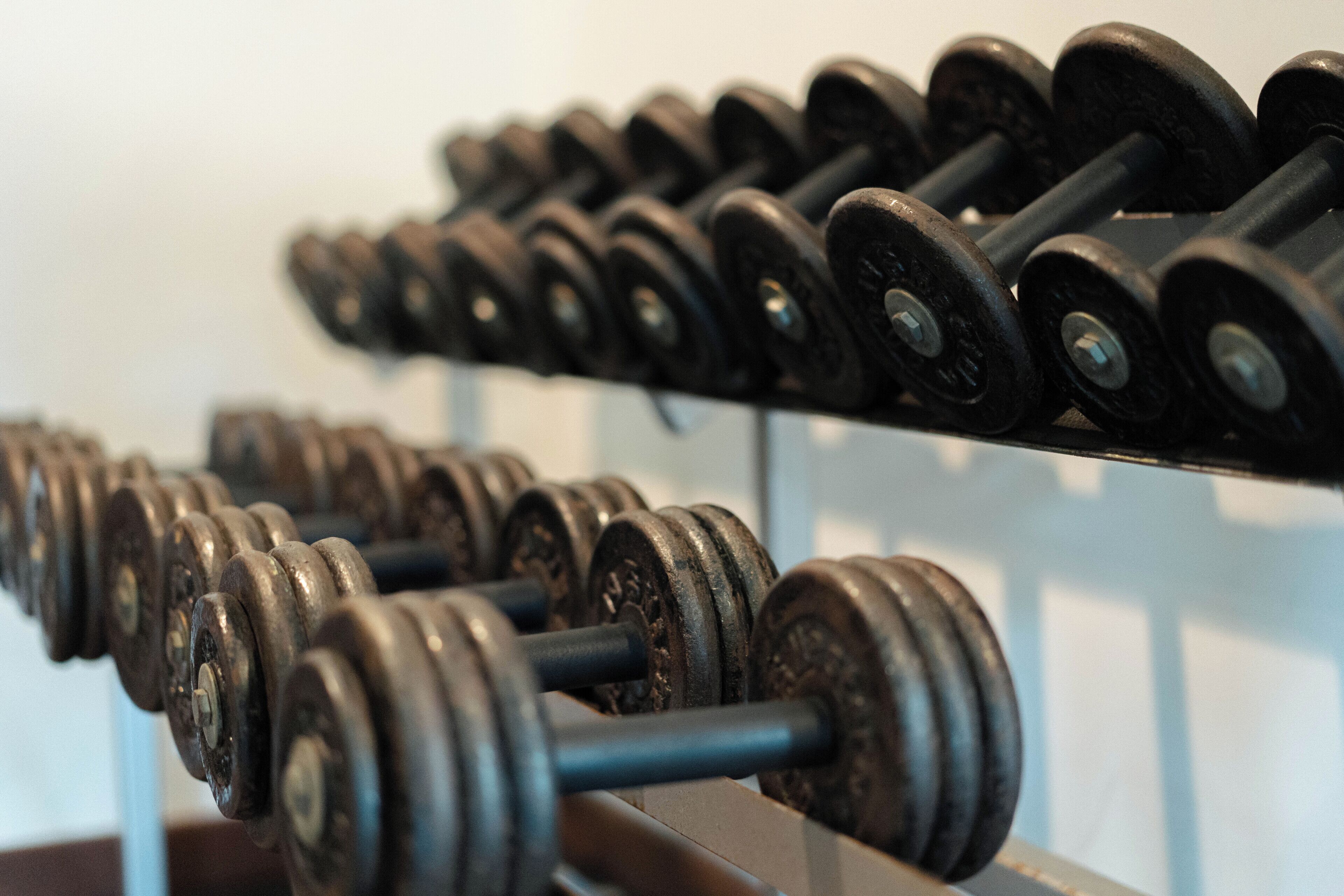 A rack of dumbbells in a gym setting.