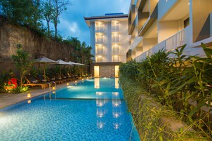 Una piscina al aire libre, tumbonas