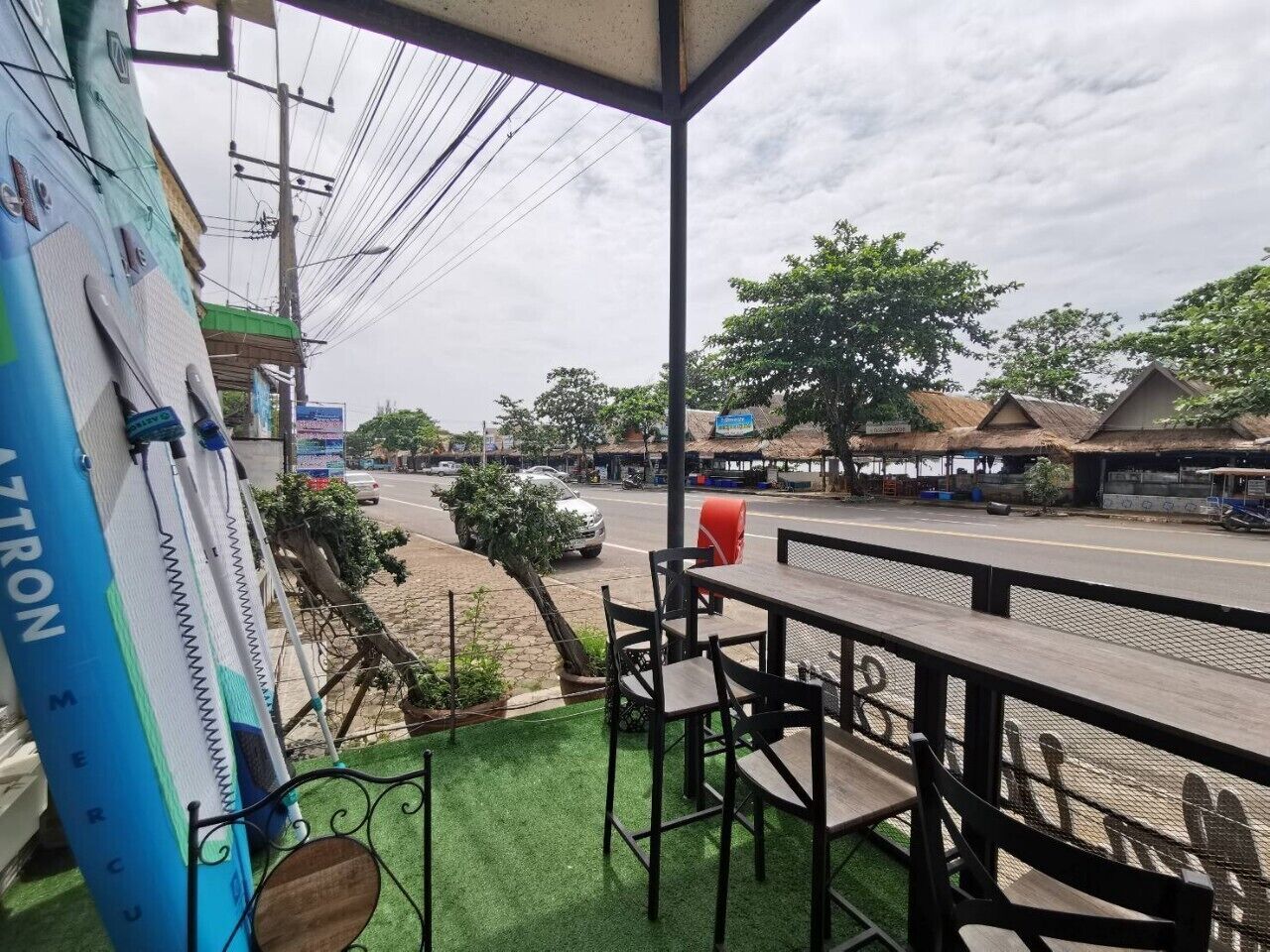Un restaurante con terraza, vista a la calle y un letrero azul que dice 'AZTRON'.