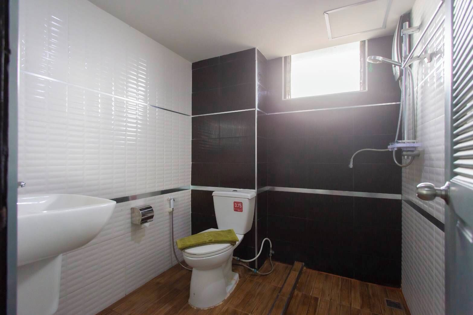 A small bathroom with a white sink, a toilet, and a shower.
