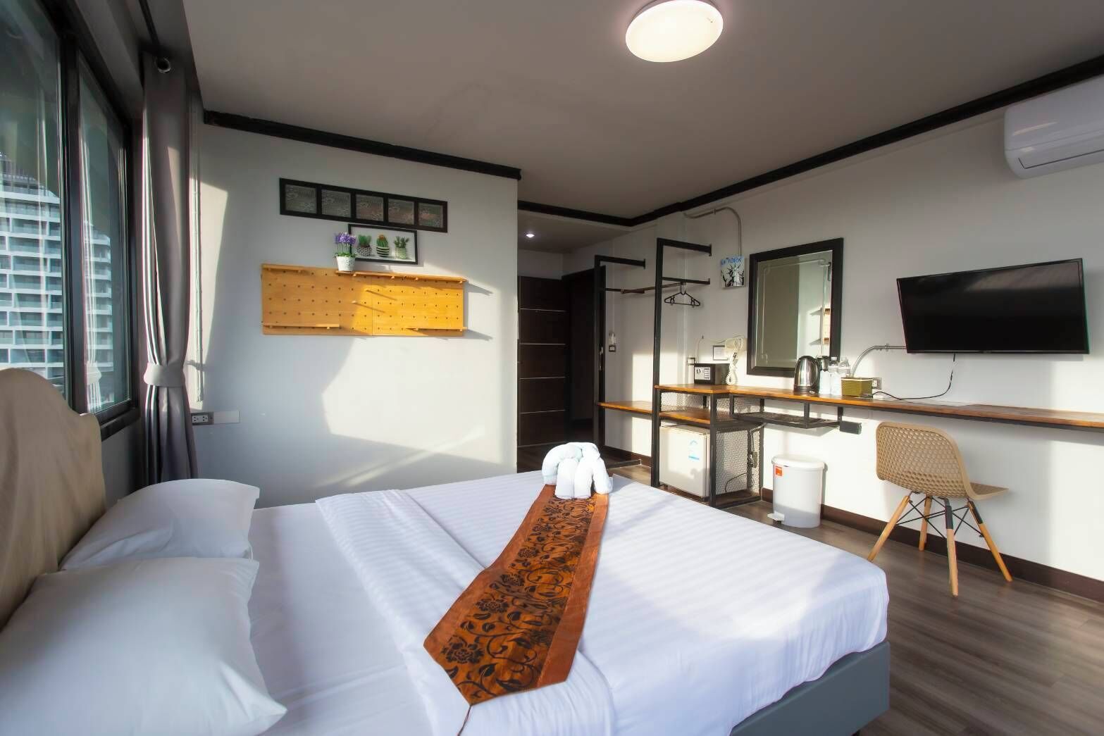 Una habitación de hotel con una cama, un escritorio, una silla, un televisor y una ventana.