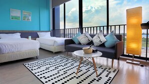 A hotel room with a large balcony, two beds, a sofa, and a view of the city. - Eco Garden Residences (Kandal Stueng)