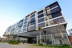 A modern multi-story building with large glass windows and a flat roof. - Eco Garden Residences (Kandal Stueng)