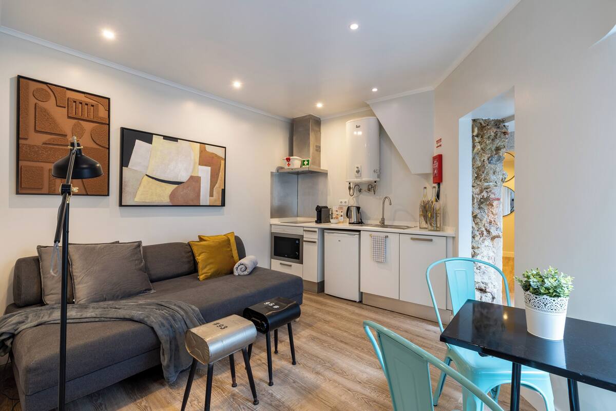Un espacio habitable compacto con sofá, mesa de centro y comedor.