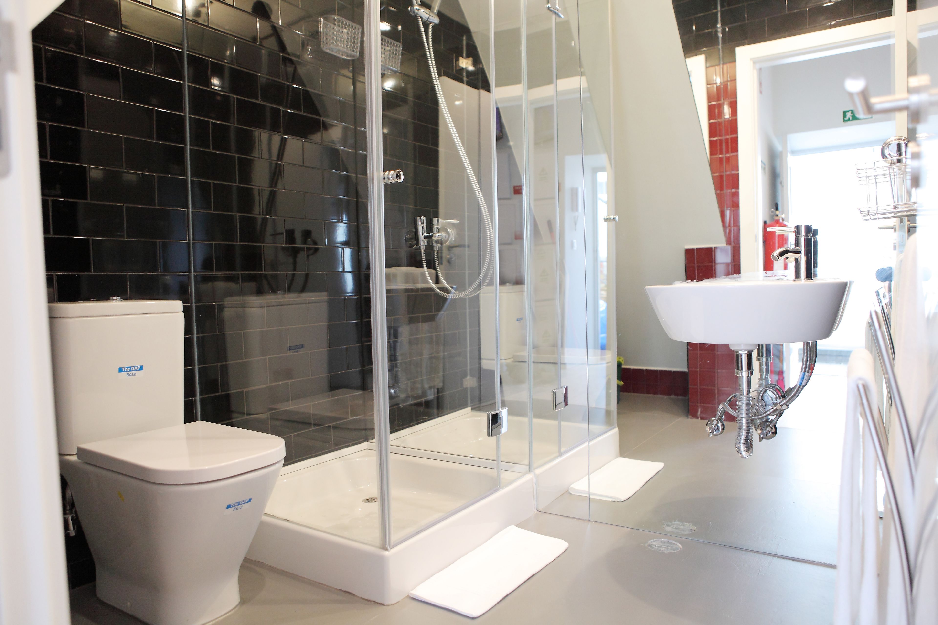 Une salle de bain moderne avec des toilettes, une douche à parois de verre et un lavabo blanc.