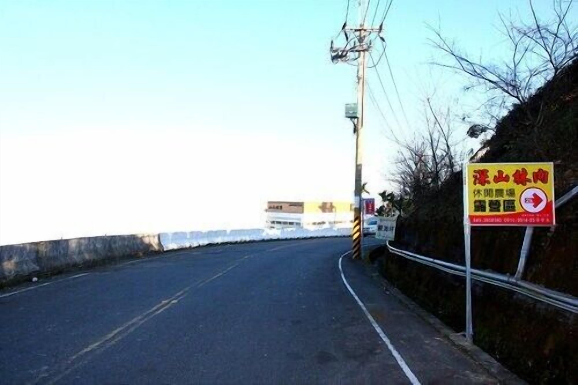 A road with a yellow sign indicating a no parking zone.