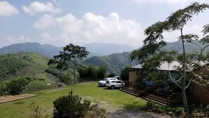 A property with a view of mountains, a paved driveway, and a white car parked in the yard. - Shen Shan Lin Nai B&B (Zhushan)