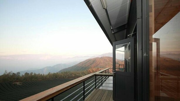 A modern building with a balcony overlooking a mountainous landscape. - Shen Shan Lin Nai B&B (Zhushan)