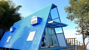 A blue, triangular-shaped building with a wooden deck and steps leading up to it. - Shen Shan Lin Nai B&B (Zhushan)