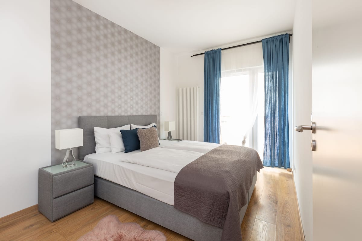 Ein modernes Schlafzimmer mit einem Bett, Nachttischen und einem flauschigen Teppich.