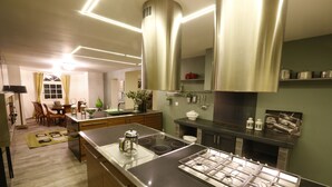 Une cuisine moderne dotée d’un îlot central, d’appareils électroménagers en acier inoxydable et d’un coin repas avec des meubles en bois.