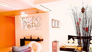 A modern living room with a sofa, a coffee table, and a decorative wall with circular patterns. - Residence Tifaouine Agadir (Agadir)