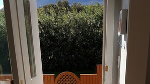 A doorway leading to a wooden deck with a fire extinguisher and a rug. - The Viking Country Club (Hjalteyri)
