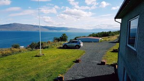 A house with a gravel driveway leading to a car parked in front. - The Viking Country Club (Hjalteyri)