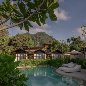 A pool area with lounge chairs and a view of a mountain. - The Spa Resorts (Surat Thani)
