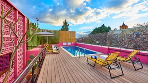 A rooftop pool area with lounge chairs, a pool, and a view of a temple in the background. - City Centro by Marriott Oaxaca (Oaxaca)