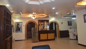 A spacious lobby with a central bar area, decorative arches, and a ceiling fan. - Kim Beatriz Compound (Lapu-Lapu)
