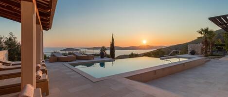 Een buitenzwembad, een infinity pool, parasols voor strand/zwembad