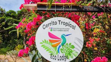 Schild für das Cerrito Tropical Eco Lodge mit Kontaktinformationen und Social-Media-Profilen.