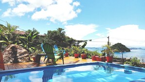Une piscine avec vue sur la mer et un pont en arrière-plan.