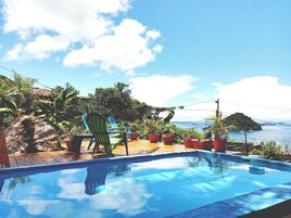 Una piscina con vistas al mar y un puente al fondo.