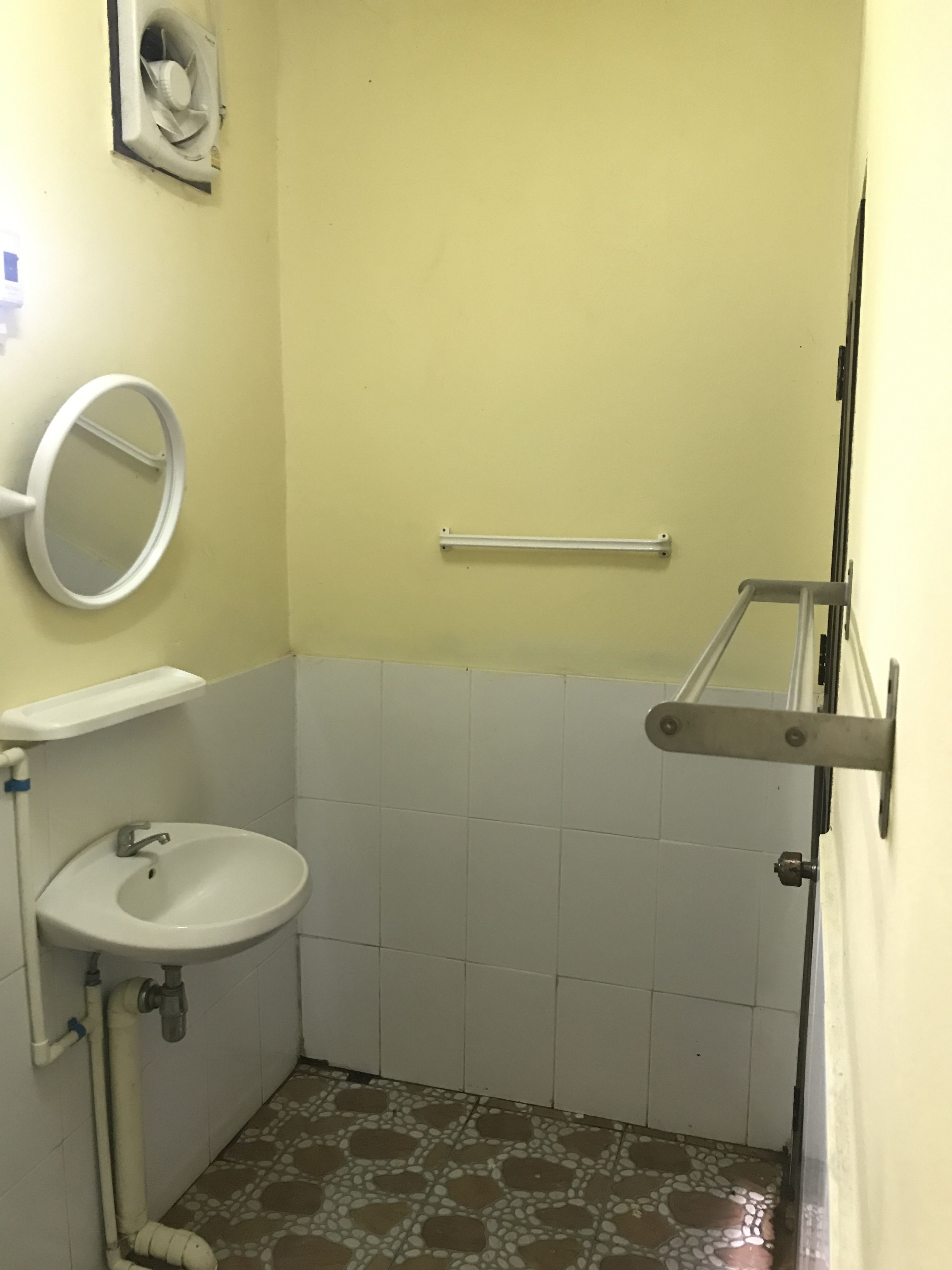 Un baño pequeño con lavamanos, espejo y toallero.
