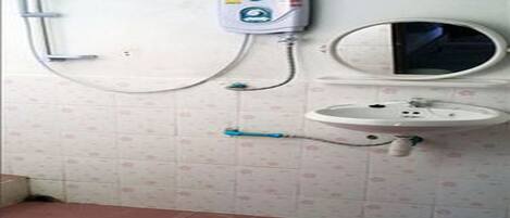 A bathroom with a toilet, a sink, and a mirror.
