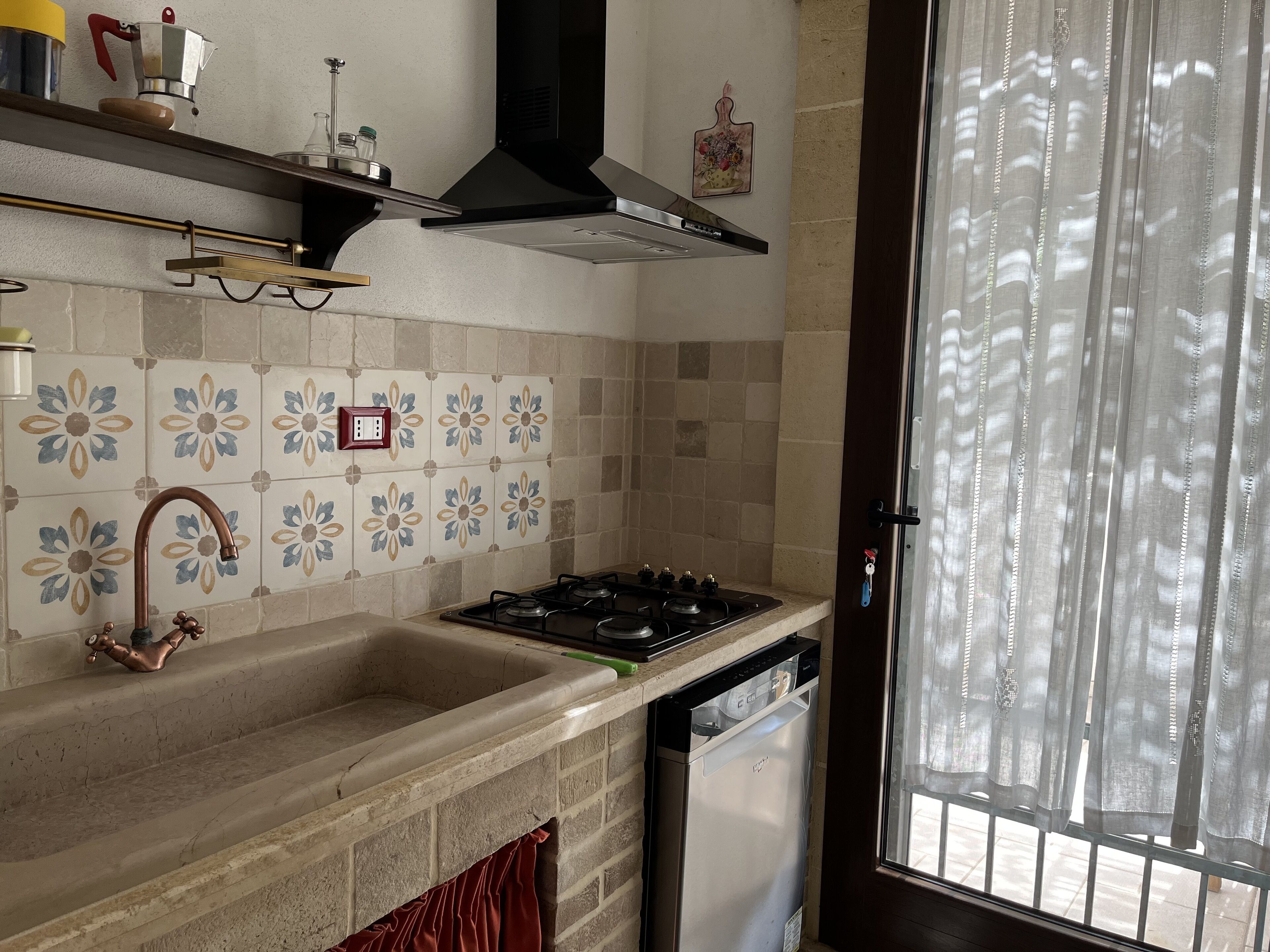 Una cocina con estufa a gas, horno empotrado, pileta y lavavajillas.