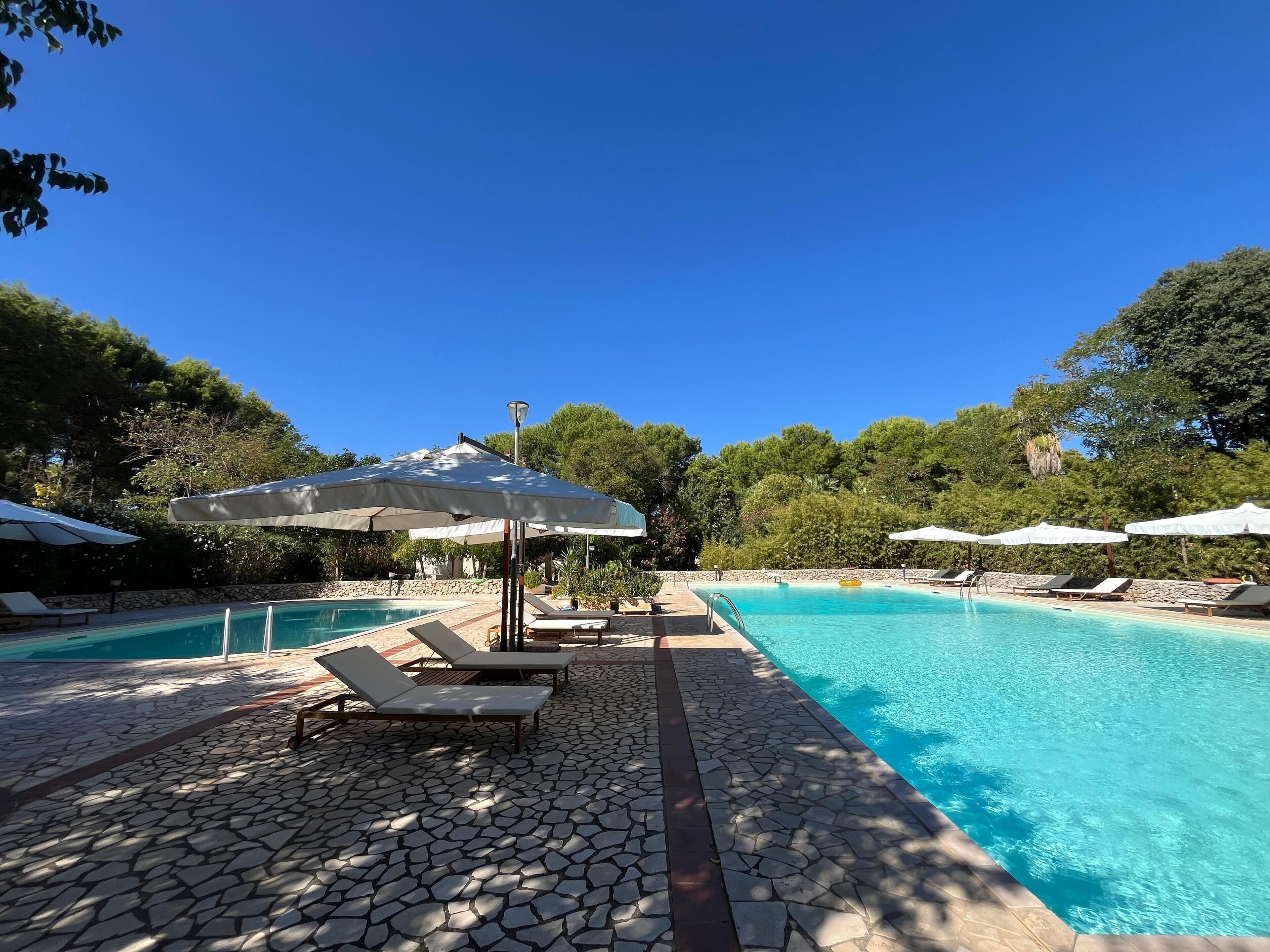 季节性开放的室外游泳池，池畔遮阳伞，日光浴躺椅