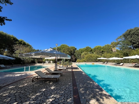 Alberca al aire libre por temporada y sombrillas en la alberca