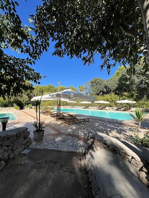 Een seizoensgebonden buitenzwembad en parasols bij het zwembad