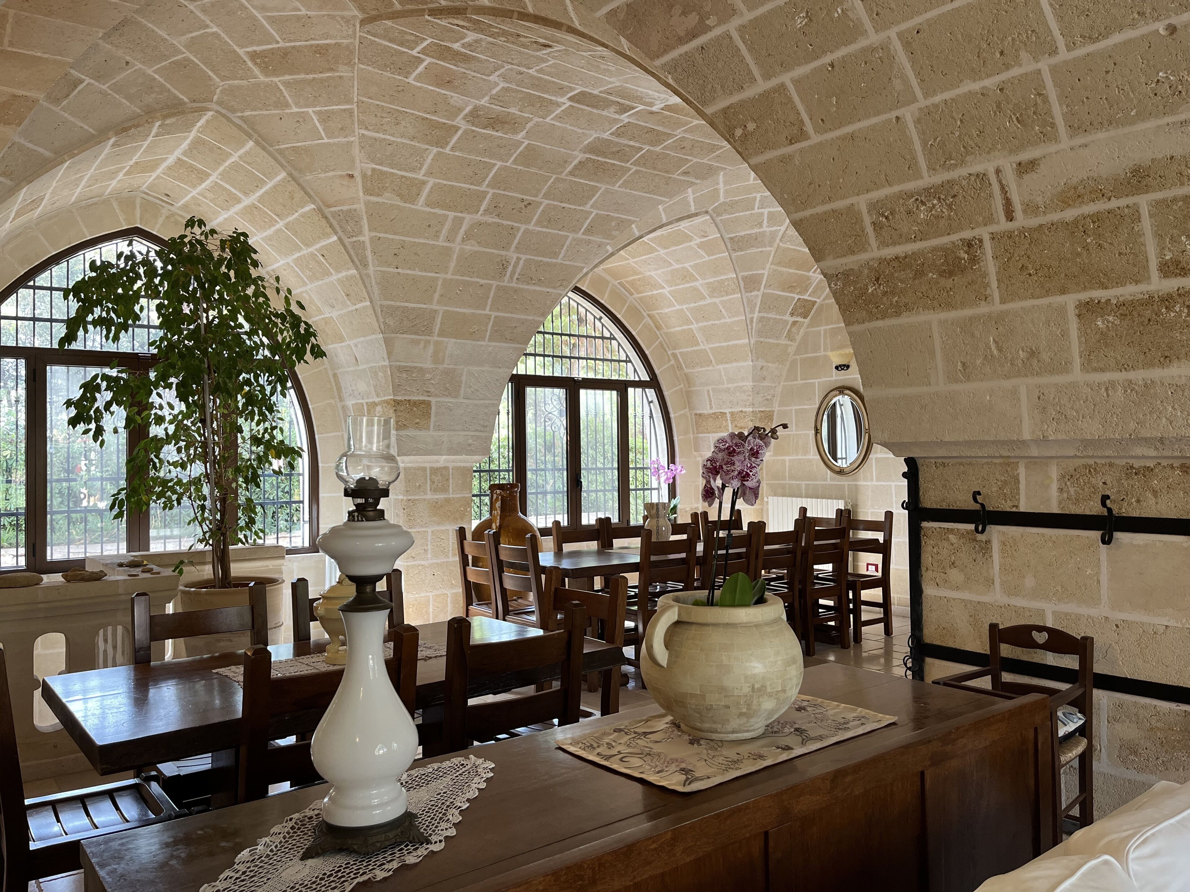 Un comedor con techos altos de ladrillo abovedados, mesas y sillas de madera.