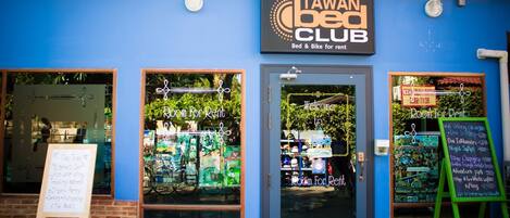 A storefront with a sign reading "Tawan Bed Club" and "Room for Rent."