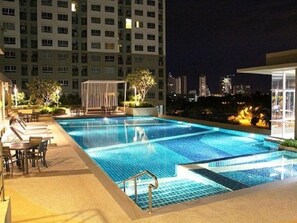 Ein Pool auf dem Dach mit Blick auf eine nächtliche Skyline.