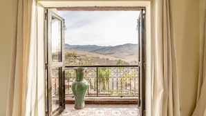 A balcony with a view of a mountainous landscape, a green vase, and a patterned floor. - Dar Tafantant (Ourika)